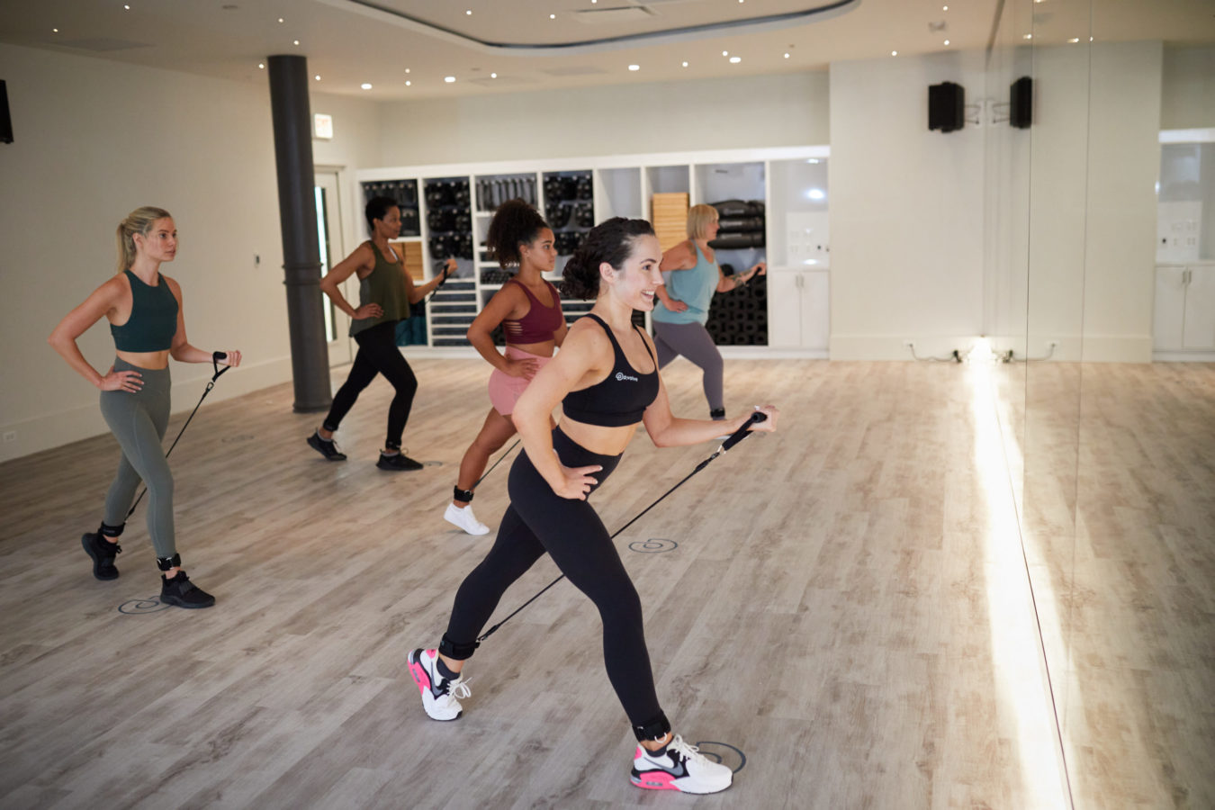 Group of women exercise in boutique fitness studio using P.volve equipment